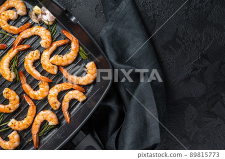 Prawns Shrimps roasted on pan with lemon and garlic. Black background. Top view. Copy space Prawns Shrimps roasted on pan with lemon and garlic. Black background. Top view. Copy space 89815773