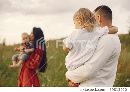 Family with cute little child. Father in a white shirt. Sunset background. 89815930