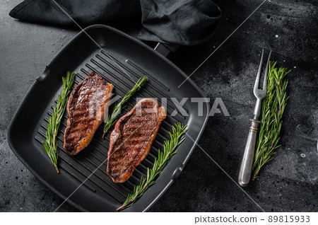 Grilled Top sirloin beef steak or brazilian Picanha, roasted meat on grill pan. Black background. Top view Grilled Top sirloin beef steak or brazilian Picanha, roasted meat on grill pan. Black background. Top view 89815933