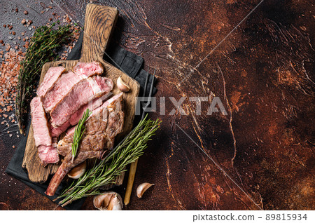 BBQ Grilled Tomahawk Steak, Rib eye on a wooden board. Dark background. Top view. Copy space BBQ Grilled Tomahawk Steak, Rib eye on a wooden board. Dark background. Top view. Copy space 89815934