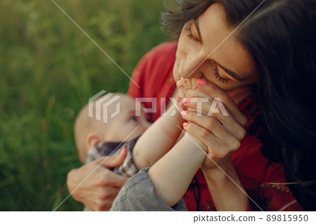 Mother with cute daughter. Mom breastfeeding her little son. Woman in a red dress. Mother with cute daughter. Mom breastfeeding her little son. Woman in a red dress. 89815950