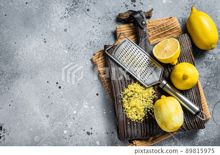 Raw grated Lemon Zest peel on wooden board. Gray background. Top view. Copy space Raw grated Lemon Zest peel on wooden board. Gray background. Top view. Copy space 89815975