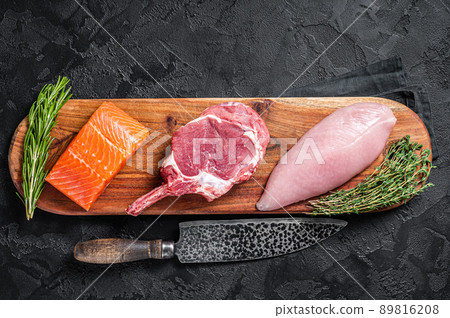 Raw meat steaks - fish salmon, beef veal and turkey. Black background. Top view 89816208