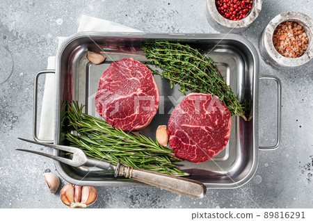 Raw Fillet Mignon beef steaks from tenderloin. Gray background. Top view Raw Fillet Mignon beef steaks from tenderloin. Gray background. Top view 89816291