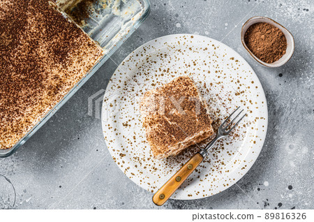 Tiramisu Italian dessert topped with cocoa on a plate. Gray background. Top view 89816326