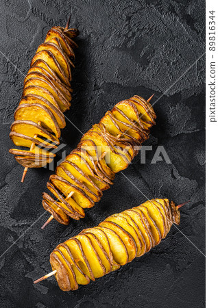 Twisted tornado potatoes chips. Black background. Top view 89816344