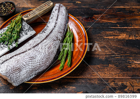 Fresh Raw grenadier macrurus white fish without head. Dark Wooden background. Top view. Copy space 89816399
