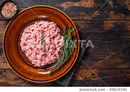 Ground chicken or turkey meat, raw Poultry on rustic plate with herbs. Dark background. Top View. Copy space Ground chicken or turkey meat, raw Poultry on rustic plate with herbs. Dark background. Top View. Copy space 89816506