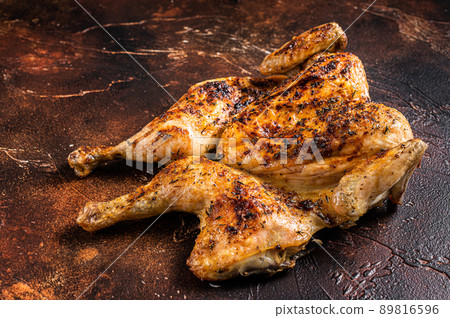 Whole roasted Chicken rotisserie with herbs. Dark background. Top view Whole roasted Chicken rotisserie with herbs. Dark background. Top view 89816596