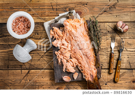 Hot smoked salmon fish fillet on a wooden board. Wooden background. Top view 89816630