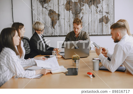 People are working on the project. Men and women in suits sitting at the table. Businessmen use a laptop. People are working on the project. Men and women in suits sitting at the table. Businessmen use a laptop. 89816717
