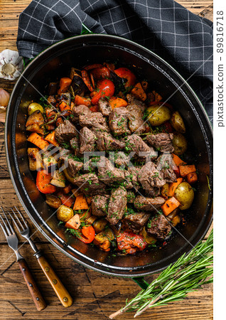 Beef meat stew with potatoes, carrots and herbs. Wooden background. Top view Beef meat stew with potatoes, carrots and herbs. Wooden background. Top view 89816718