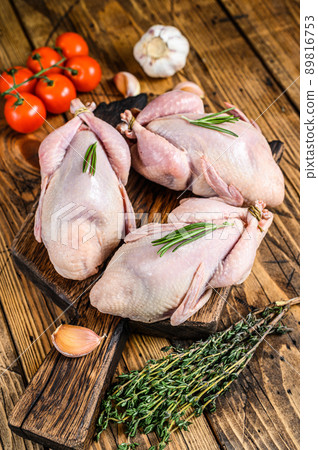 Raw quails on a cutting board. wooden background. Top view Raw quails on a cutting board. wooden background. Top view 89816753