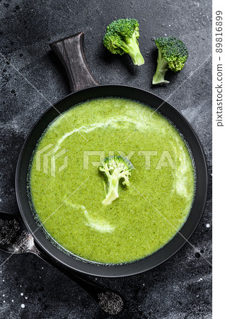 Fresh cream broccoli and pea soup in plate . Black background. Top view 89816899