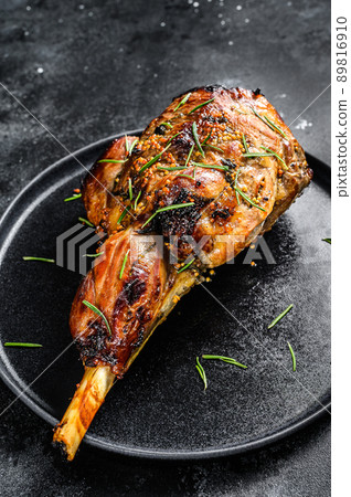 Oven baked lamb leg. Dark background. Top view Oven baked lamb leg. Dark background. Top view 89816910