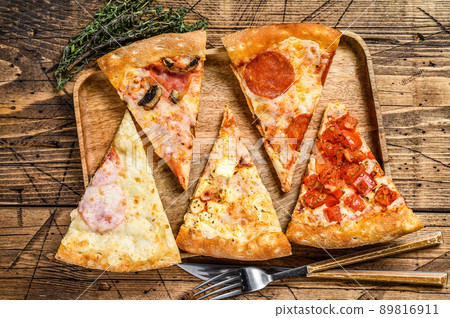 Pieces of different pizza various types. Wooden background. Top view Pieces of different pizza various types. Wooden background. Top view 89816911