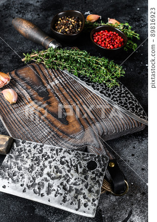 Old Used Meat Cleaver and knife with wooden cutting board. Black background. Top view Old Used Meat Cleaver and knife with wooden cutting board. Black background. Top view 89816923