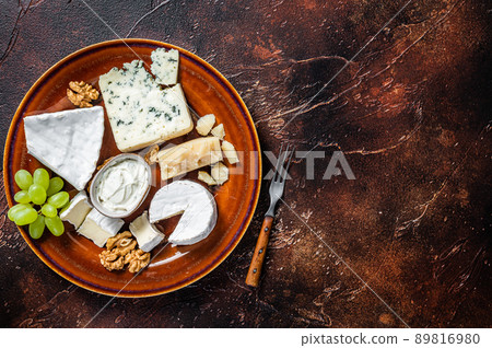 Cheese plate with Brie, Camembert, Roquefort, blue cream cheese, grape and nuts. Dark background. Top view. Copy space 89816980