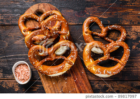 Homemade Soft Pretzels with Salt on a wooden board. Dark wooden background. Top view Homemade Soft Pretzels with Salt on a wooden board. Dark wooden background. Top view 89817097