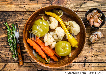 Salted and pickles vegetables preserve in a wooden plate. wooden background. Top view 89817243