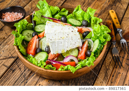 Greek salad with fresh vegetables and feta cheese. Wooden background. Top view Greek salad with fresh vegetables and feta cheese. Wooden background. Top view 89817361