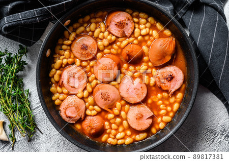 Beans with sausages in tomato sauce in a pan. White background. Top view 89817381