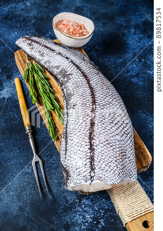 Fresh Raw grenadier macrurus white fish on a wooden cutting board. Blue background. Top view 89817534