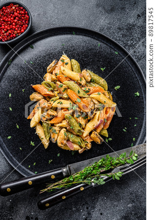 Italian Color Penne pasta with mussels on a plate. Black background. Top view Italian Color Penne pasta with mussels on a plate. Black background. Top view 89817545