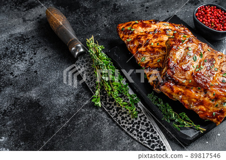 Barbecue pork rack spare ribs on a marble board. Black background. Top view. Copy space 89817546