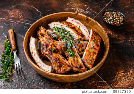 Cut BBQ grilled lamb rack spareribs in a wooden plate. Dark background. Top view Cut BBQ grilled lamb rack spareribs in a wooden plate. Dark background. Top view 89817550