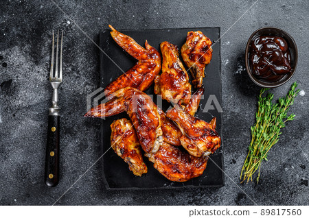 Hot Barbecue chicken wings with sauce bbq. Black background. Top view 89817560