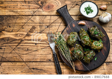 Traditional georgian dolma in grape leaves. wooden background. Top view. Copy space Traditional georgian dolma in grape leaves. wooden background. Top view. Copy space 89817688