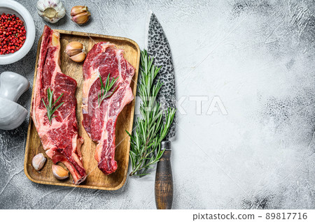 Raw cuts of beef marble meat on the bone. White background. Top view. Copy space Raw cuts of beef marble meat on the bone. White background. Top view. Copy space 89817716