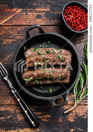 Grilled mince meat sausages in a pan. Dark wooden background. Top view 89817763
