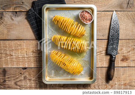 Uncooked raw Tornado or Twist potato fries. Wooden background. Top view Uncooked raw Tornado or Twist potato fries. Wooden background. Top view 89817913