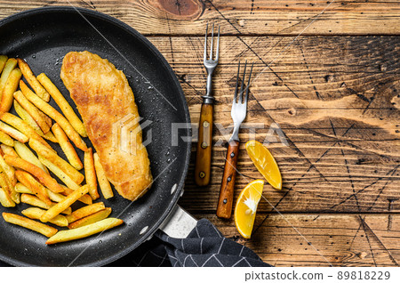 English Traditional Fish and chips dish in a pan. Wooden background. Top view. Copy space English Traditional Fish and chips dish in a pan. Wooden background. Top view. Copy space 89818229