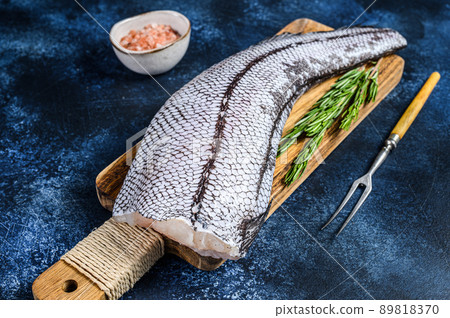 Fresh Raw grenadier macrurus white fish on a wooden cutting board. Blue background. Top view Fresh Raw grenadier macrurus white fish on a wooden cutting board. Blue background. Top view 89818370