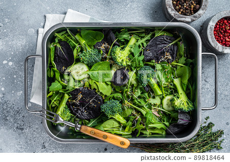 Mix fresh leaves of arugula, lettuce, spinach, beets for vegan salad. Gray background. Top view 89818464