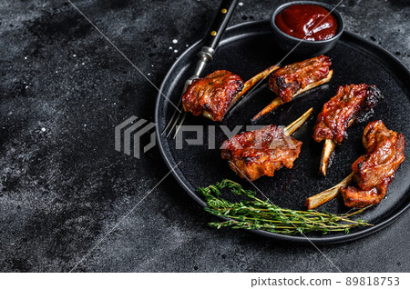 BBQ grilled sliced veal short spare loin ribs. Black background. Top view. Copy space BBQ grilled sliced veal short spare loin ribs. Black background. Top view. Copy space 89818753