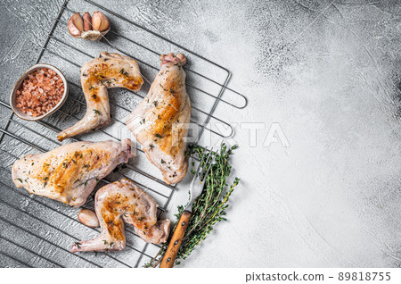 Baked rabbit legs on a grill with thyme. White background. Top view. Copy space Baked rabbit legs on a grill with thyme. White background. Top view. Copy space 89818755
