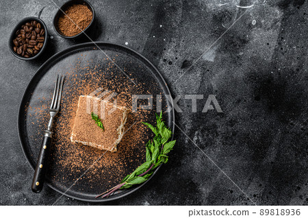 Italian Tiramisu cake with cocoa and mint on a plate. Black background. Top view. Copy space 89818936