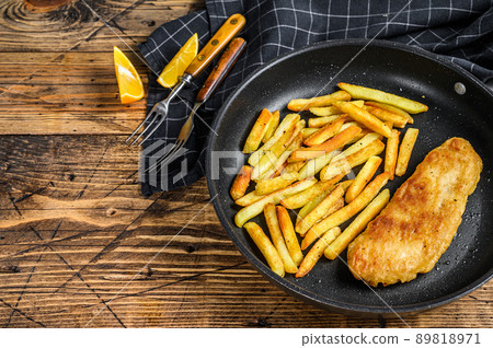 English Traditional Fish and chips dish in a pan. Wooden background. Top view. Copy space 89818971