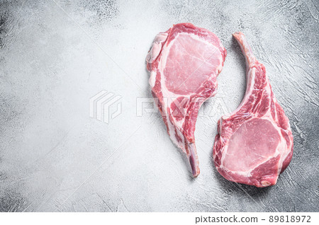 Raw dry aged tomahawk pork chop steak. White background. Top view. Copy space 89818972