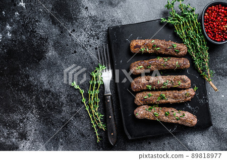 Grilled Shish kebab meat sausages. Black background. Top view. Copy space 89818977