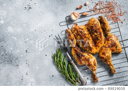 Traditional spatchcocked barbecue chicken on grill. Gray background. Top view. Copy space 89819038