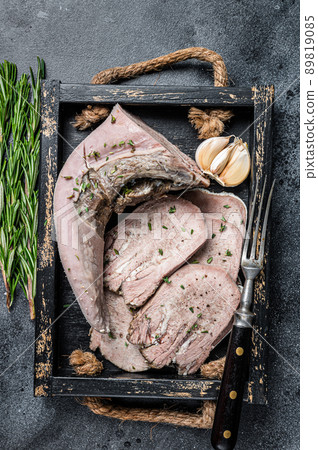 Cooked Boiled veal or beef tongue sliced in a wooden tray. Black background. Top view Cooked Boiled veal or beef tongue sliced in a wooden tray. Black background. Top view 89819085