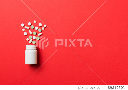 Multicolored pills and capsules in plastic bottle on Colored background, copy space. Many different various medicine tablets and pills, vitamin and nutritional supplements concept 89819301