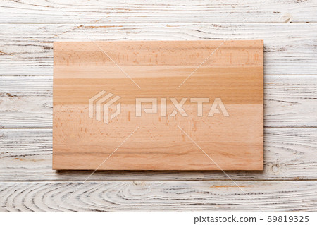 Top view of wooden cutting board on wooden background. Empty space for your design. 89819325