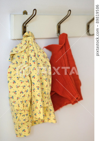 old children clothes hanging on a wall 89819586