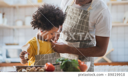 African American father and son cooking in the kitchen, helping to get dressed African American father and son cooking in the kitchen, helping to get dressed 89819918